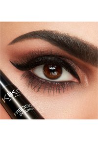 Eyeliner liquide noir dans un tube cylindrique, présenté à côté d'un gros plan d'un œil marron avec des cils dramatiques et un sourcil défini.
