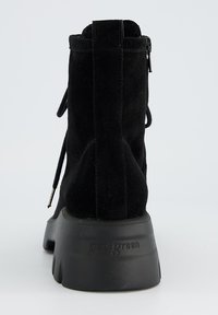 Bottines en daim noir avec une finition texturée, un bout arrondi et une épaisse semelle en caoutchouc. Comprend un design à lacets et un zip à l'arrière.