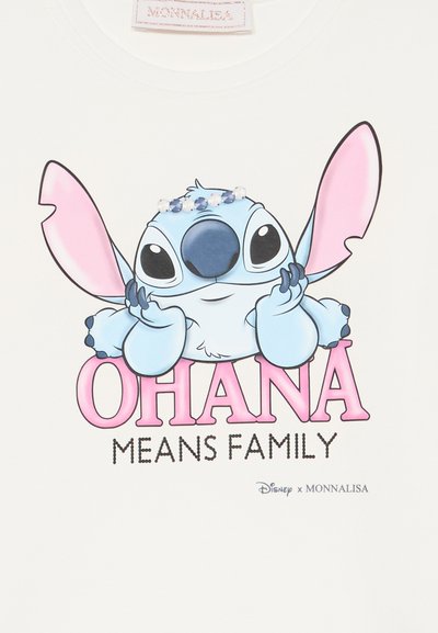 Hvit t-skjorte med en tegneseriefigur med blå pels, store ører og svarte øyne. Teksten sier "OHANA BETYR FAMILIE" i rosa og svart.