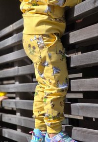 Gula bomullsträningsbyxor med lekfulla djurillustrationer, i en åtsittande design och med fickor. Parat med färgglada, reflekterande sneakers.