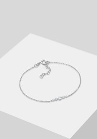 Bracciale in argento con catena, caratterizzato da cinque gemme trasparenti circolari, alternate per dimensione, con chiusura a gancio e lunghezza regolabile.