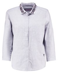 Jasnoniebieska, długi rękaw koszula zapinana na guziki z haftowanym kołnierzykiem. Posiada przednią kieszeń i subtelny paskowany wzór na całej powierzchni.