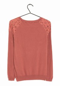Maglione a maniche lunghe color ruggine con dettagli in pizzo floreale sui pannelli delle spalle, esposto su una gruccia nera su uno sfondo bianco.