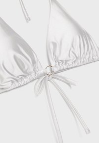 Haut de bikini triangle en satin blanc avec bretelles à nouer et un petit anneau doré au centre devant.