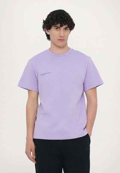 T-shirt en coton violet avec un col rond et des manches courtes. Présente un petit détail de texte imprimé sur la partie gauche de la poitrine.