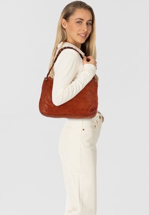 Borsa a tracolla in pelle marrone con una texture morbida e una forma curva, dotata di una tracolla intrecciata e dettagli metallici. Indossata sulla spalla.