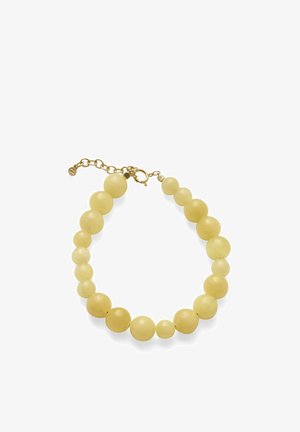 Bracelet de perles rondes jaunes avec fermoir en or et chaîne réglable sur fond blanc.