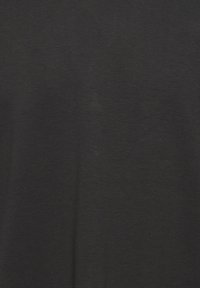 Camiseta negra de tejido suave, con una textura lisa y un diseño simple sin patrones ni adornos.