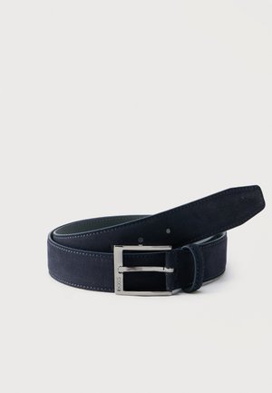 Κυλιόμενη ζώνη από σκούρο μπλε σουέντ με ασημένια ορθογώνια αγκράφα χαραγμένη με την ένδειξη "BOSS" σε απλό φωτεινό φόντο.