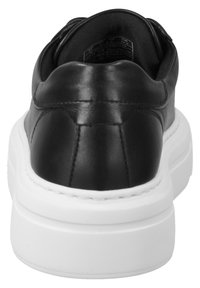 Must musta sneaker ümmarguse varbaga ja madala profiiliga valge kummitald. Silmapaistev õmblusdetail kaeluse ja kanna piirkonnas.