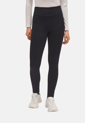 Leggings negros de tiro alto con una tela suave y elástica. Presentan una cinturilla ancha, un diseño ajustado y un aspecto limpio y minimalista.
