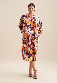 Blumendruckkleid in lebhaften Farbtönen von Pink, Weiß und Gelb. Verfügt über einen kragenlosen Ausschnitt und eine lockere Passform.