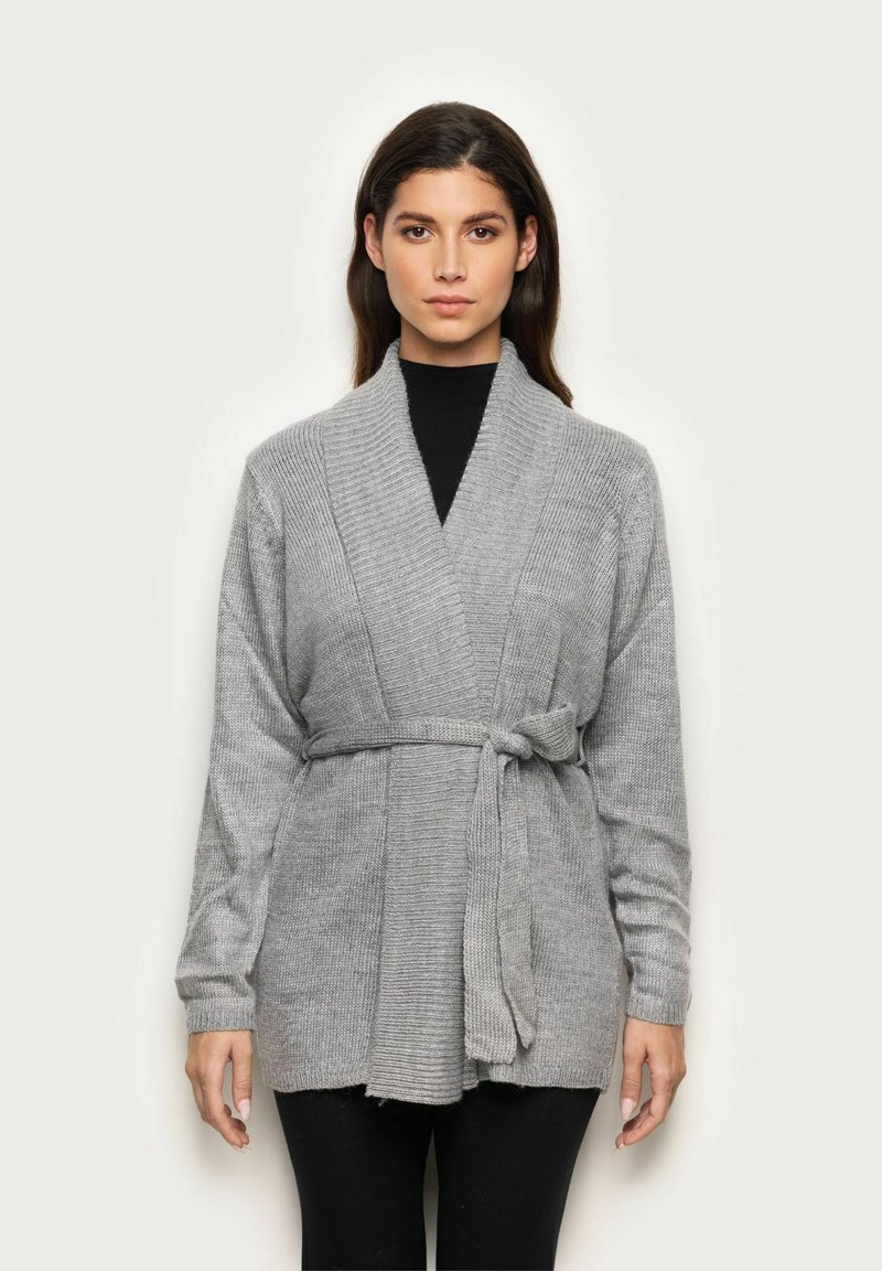 Cardigan tricotat gri cu un design înfășurat, mâneci lungi, curea laterală și textură canalată. Dispune de o guler tip șal și o margine inegală.