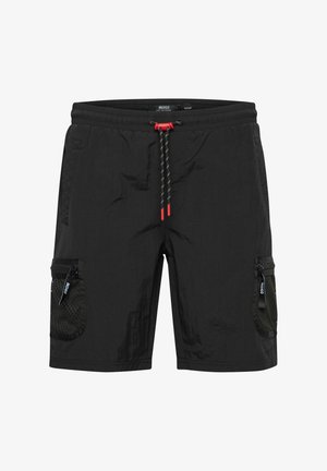 Kerged mustad lühikesed püksid, mis on valmistatud kerge materjali koosseisust, millel on nööriga talje, silmadega detailid ja kaks tõmblukuga taskut külgedel.