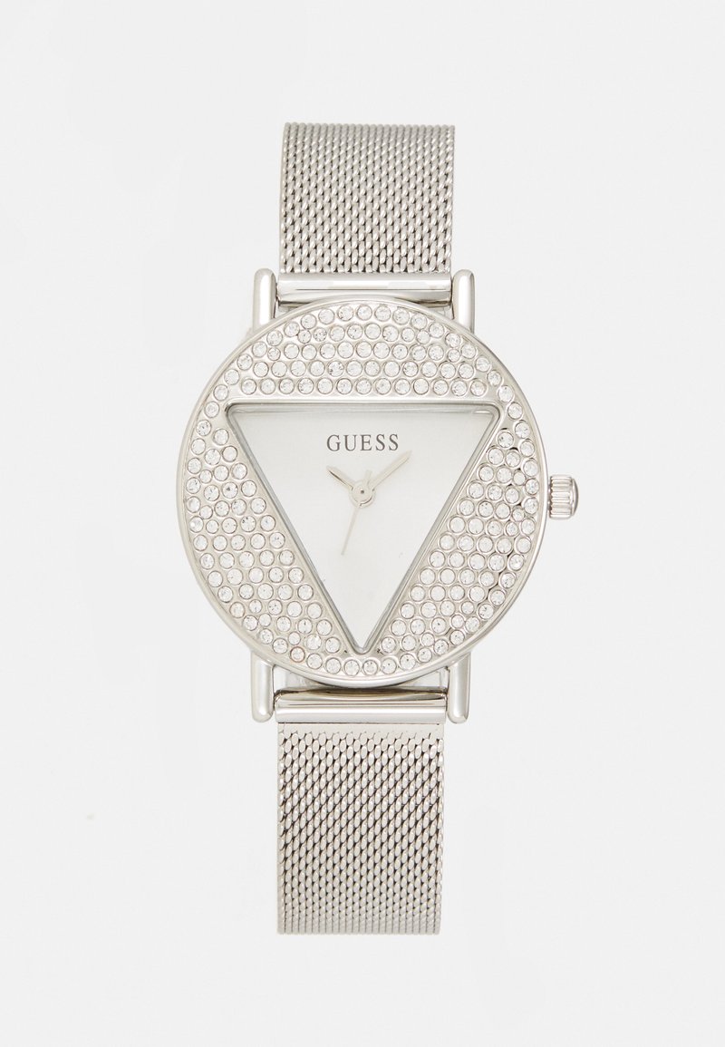 Hõbedane võrgurihmaga kell, millel on kolmnurkne kristallidega äär, ümmargune kellanägu ja minimalistlik disain. Valge kellaplaat hõbedaste käte ja brändi logoga.