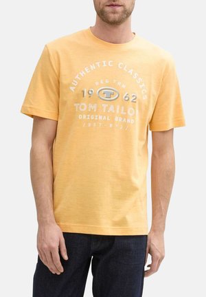 T-shirt en coton jaune à manches courtes, avec un col rond et une impression graphique en texte blanc avec les mentions "Authentic Classics" et "Tom Tailor".