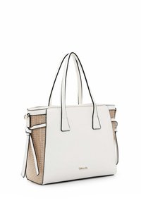 Sac fourre-tout blanc avec une surface texturée, des bords noirs et des panneaux latéraux en tissé. Doté de doubles poignées et d'un détail décoratif de lien sur le côté.