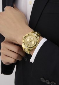 Montre en or avec un cadran texturé, trois sous-cadrans et un bracelet à maillons. Comprend des accents en diamant et une forme de boîtier octogonale.