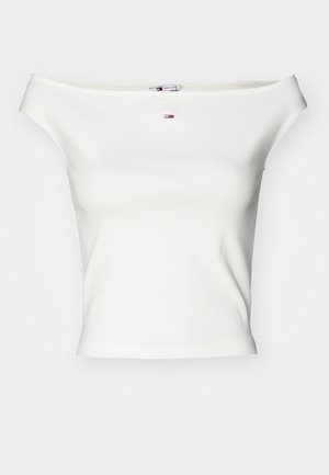 Hvid off-the-shoulder top lavet af blød bomuld, med en tætsiddende pasform og et lille logo i rød, hvid og blå i midten.