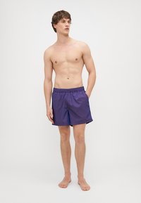 Pantaloni da bagno viola con vita elasticizzata, realizzati in materiale leggero, caratterizzati da un design a taglio dritto e senza motivi o accenti visibili.