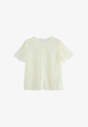 Blusa a maniche corte, con bottoni, di colore beige chiaro, con un motivo testurizzato e arricciato. Tessuto morbido e trasparente con scollatura rotonda e bordi sfrangiati.