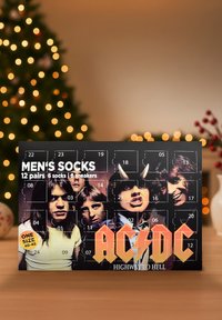 Calendario dell'Avvento di calze da uomo con 12 paia, immagini dei membri della band AC/DC, lettering arancione audace e uno sfondo scuro.