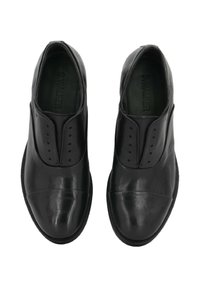 Scarpe in pelle nera con finitura liscia, pannelli laterali elasticizzati, perforazioni decorative sulla tomaia e design della punta arrotondata.