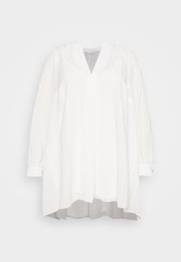 Blusa bianca trasparente a maniche lunghe con sottili righe verticali, scollatura a V, polsini abbottonati e orlo leggermente curvo.