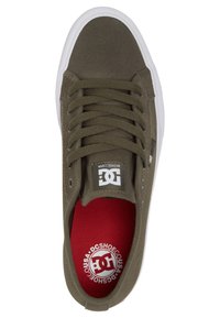 Zapatilla de lona verde oliva con suela de goma blanca, cordones planos, plantilla roja acolchada y detalle del logo en la lengüeta.