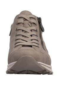 Vue de face d'une basket beige avec des lacets épais croisés et une fermeture éclair latérale sur fond blanc.