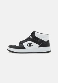 Sneaker alte con una combinazione di colori bianco e nero, materiali in pelle e rete, con dettagli del logo e suola in gomma testurizzata.
