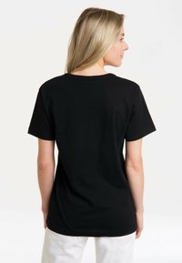 Black cotton T-shirt with short sleeves, round neckline, and a relaxed fit. Smooth texture, plain design, and no visible embellishments.