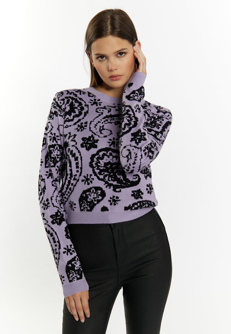 Fioletowy dziergany sweter z czarnym wzorem paisley, okrągłym dekoltem i długimi rękawami, zestawiony z dopasowanymi czarnymi spodniami.