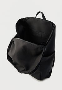 Μαύρο σακίδιο με φερμουάρ, διαθέτει ευρύχωρο υφασμάτινο εσωτερικό. Περιλαμβάνει επίπεδη εσωτερική τσέπη και απαλής υφής.