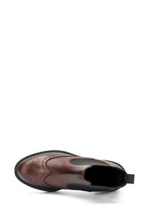 Bota Chelsea de cuero marrón con lados elásticos, detalle decorativo de brogue y suela de goma negra texturizada. Punta plana en forma de almendra.