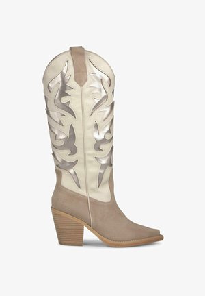 Beige Cowboy-Stiefel mit silbernen Metallic-Akzenten und Ausschnittmustern, ausgestattet mit einer strukturierten Wildlederbasis und einem gestapelten Holzabsatz.