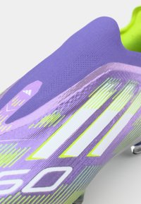 Scarpino da calcio viola con tomaia testurizzata, caratterizzato da accenti bianchi e verde neon e un design affusolato per prestazioni ottimizzate.