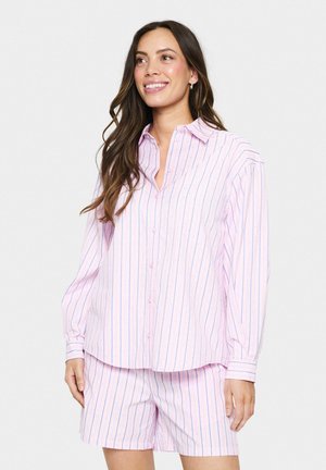 Lichtroze pyjama set met een lange mouwen overhemd met knopen, versierd met blauwe strepen en stippenpatronen, gecombineerd met bijpassende shorts. Soepele stof.