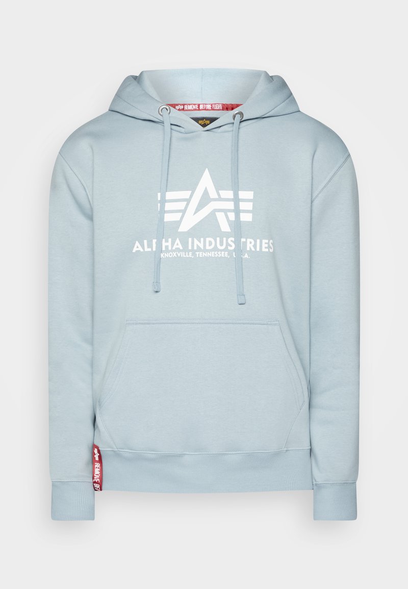 Lichtblauwe hoodie met een voorzak, koordjes en een groot wit "ALPHA INDUSTRIES" logo. Bevat geribbelde manchetten en een gebrandmerkte tag.