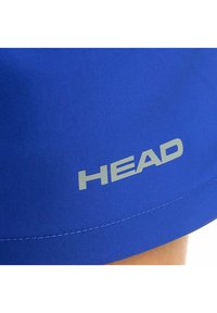 Pantaloni sportivi blu realizzati in tessuto liscio, con un logo silver "HEAD" e dettagli di cucitura visibili lungo l'orlo.