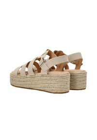 Sandalias de esparto beige con una plataforma de yute trenzado, que presentan múltiples correas anchas y un cierre de hebilla para un ajuste seguro.