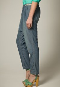 Pantaloni in denim blu a vita alta con pieghe, caratterizzati da un taglio dritto, una leggera texture sbiadita e dettagli con zip laterali.