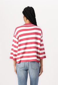 Top a maglia a righe con maniche ampie, caratterizzato da strisce orizzontali alternate in corallo e bianco. Texture morbida, vestibilità rilassata, lunghezza cropped.