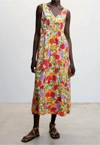 Robe maxi à motifs floraux avec décolleté en V, sans manches, motifs de fleurs multicolores vifs et taille froncée.