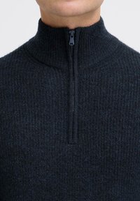 Dunkler Strick-Pullover mit Halb-Reißverschluss und strukturierter Stoff, ausgestattet mit einem Stehkragen und einem kurzen Reißverschluss am Hals.
