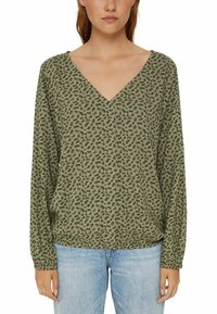 Olijfgroene blouse met lange mouwen, een V-hals en een bloemenpatroon. Zachte stof met een ontspannen pasvorm, afgerond met elastische manchetten.