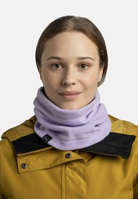 Gaiter de cuello de felpa de color púrpura claro, usado debajo de un cuello oscuro. Textura suave con una etiqueta de marca visible en el lado.