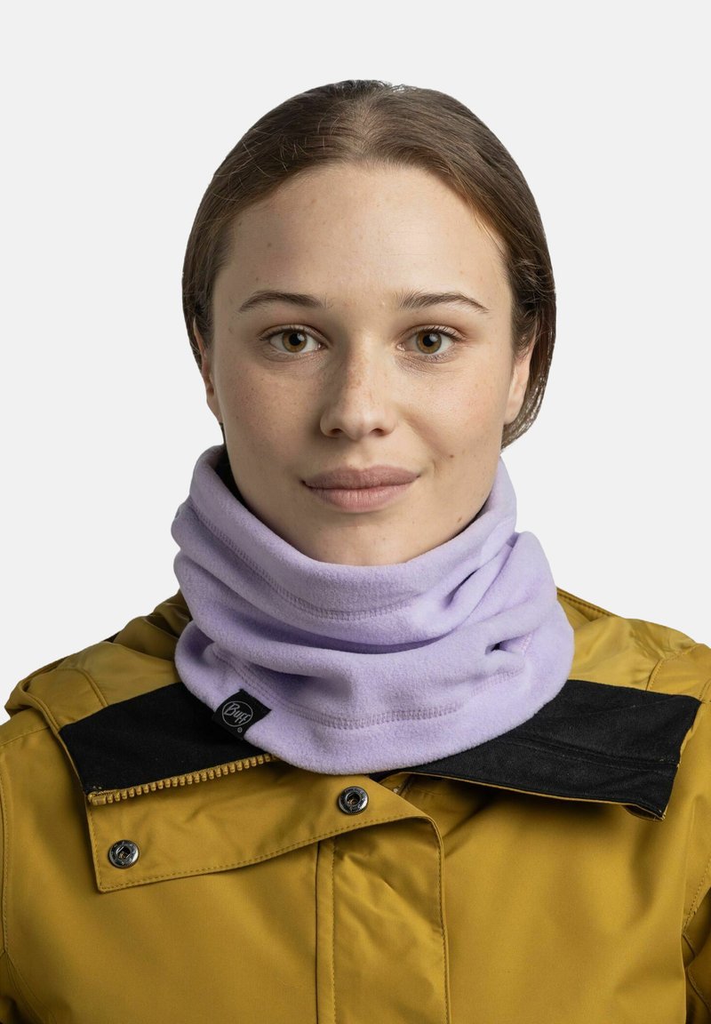 Gaiter de cuello de felpa de color púrpura claro, usado debajo de un cuello oscuro. Textura suave con una etiqueta de marca visible en el lado.