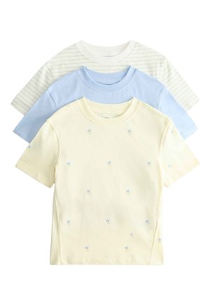 Trzy złożone koszulki z krótkim rękawem i okrągłym dekoltem: w jasnym żółtym kolorze z małymi niebieskimi kwiatkami, jednolite jasnoniebieskie oraz beżowe w cienkie zielone paski.