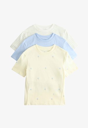 Trzy złożone koszulki z krótkim rękawem i okrągłym dekoltem: w jasnym żółtym kolorze z małymi niebieskimi kwiatkami, jednolite jasnoniebieskie oraz beżowe w cienkie zielone paski.